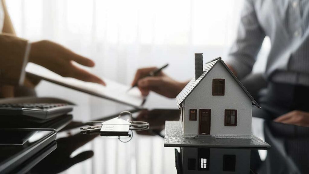 Homeowner reviewing an insurance declaration page beside a laptop, house keys, and a folder of policy documents.